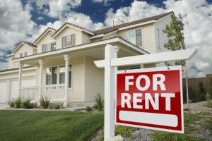 Left Facing Red For Rent Real Estate Sign in Front of Beautiful