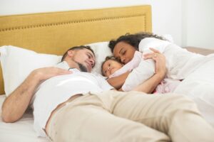 Young Family Cuddling in Bed